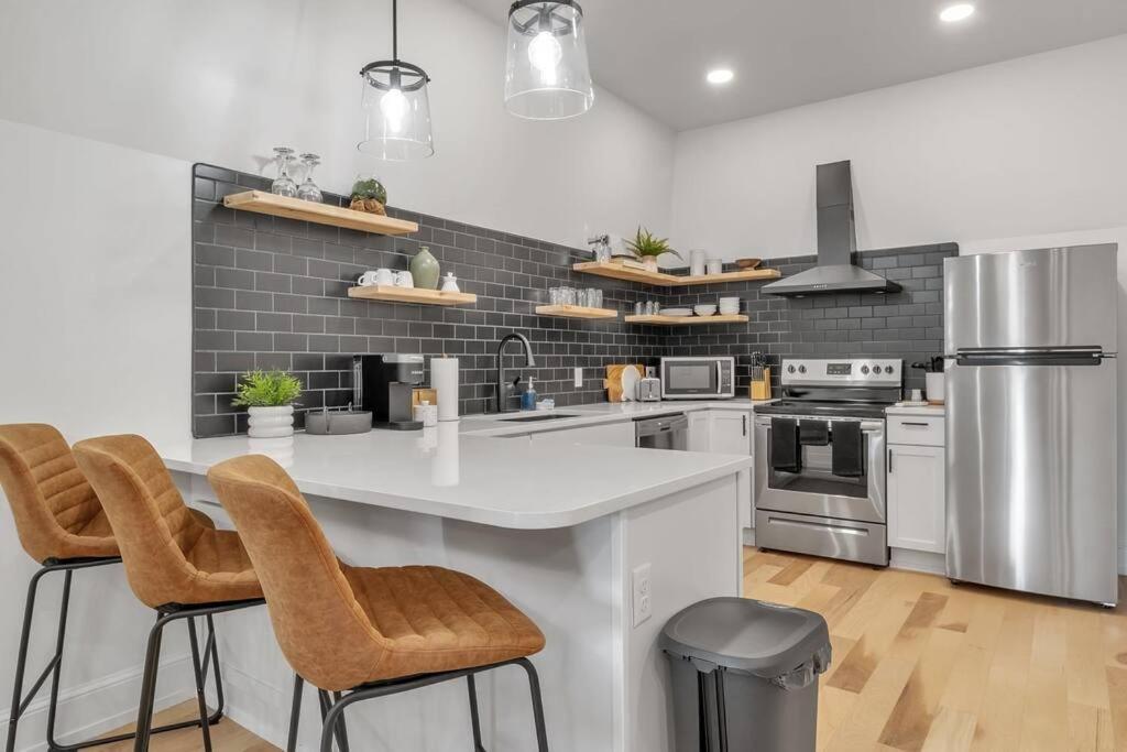 a kitchen with a white counter and stools at Carriage House Loft - King Bed and Garage Parking in Buffalo