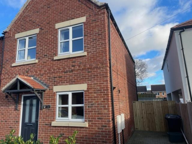 a brick house with two windows and a door at Immaculate house in Doncaster 2 in Doncaster