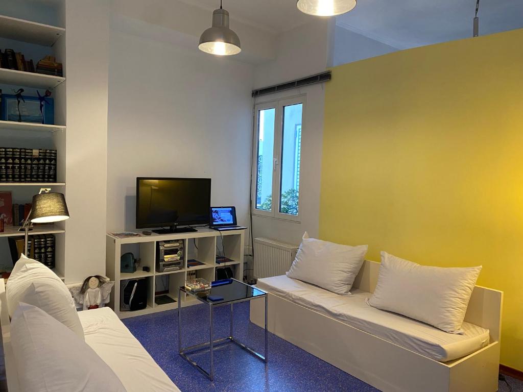 een woonkamer met een bank en een tv bij Sacred Way Modern apartment in Athene