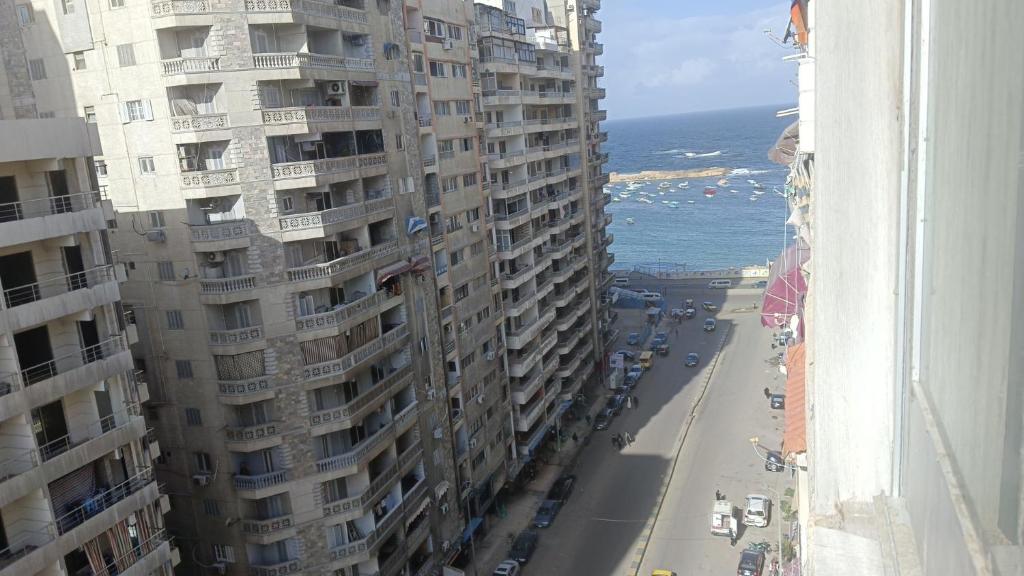 a view of a street with tall buildings and the ocean at The sea apartment in ‘Izbat al Qaşr