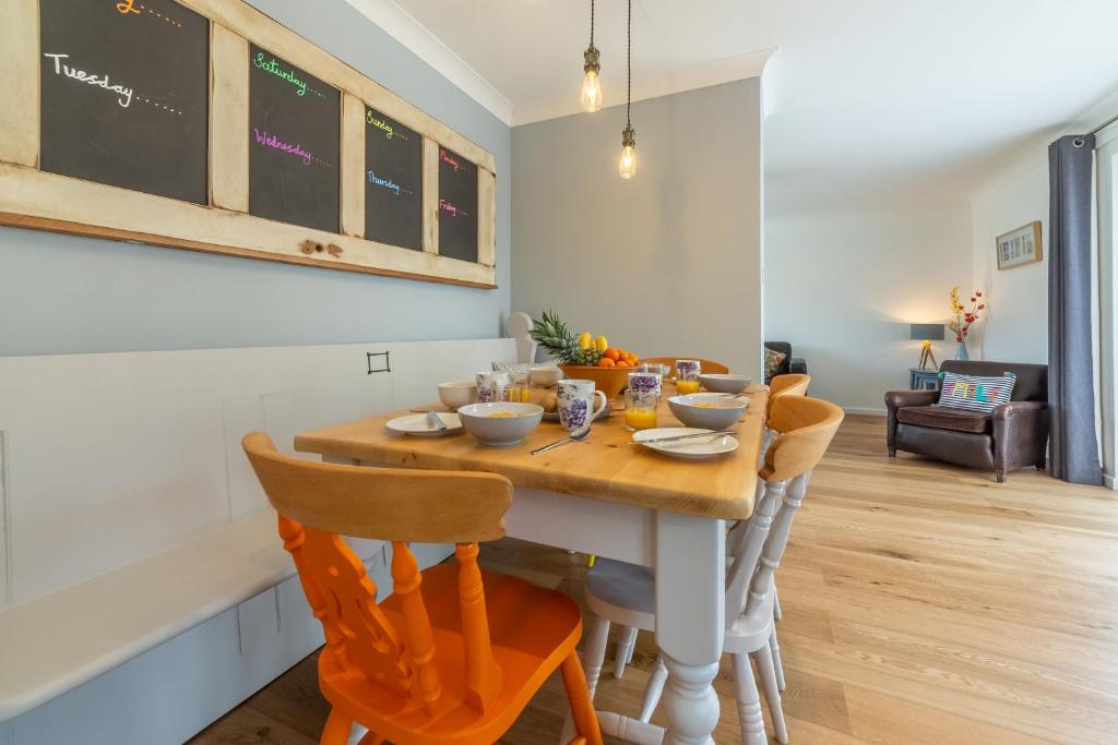 a dining room with a table with chairs and a chalkboard at One Lazy Duck in Heacham
