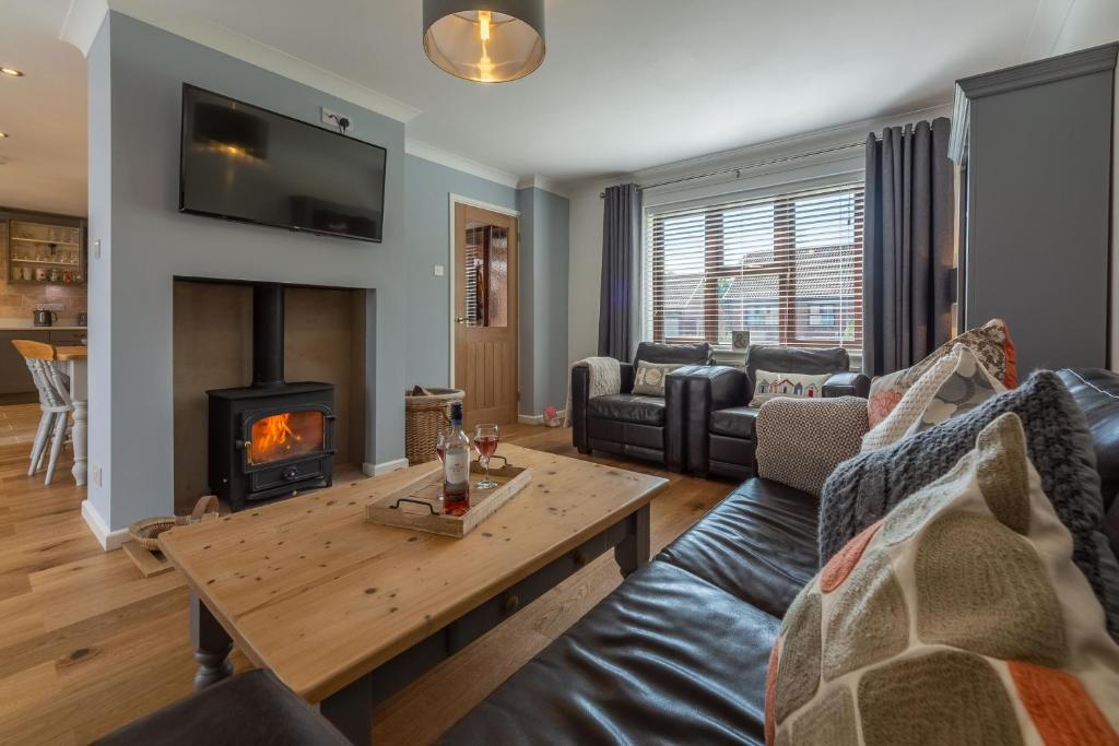 a living room with a couch and a fireplace at One Lazy Duck in Heacham