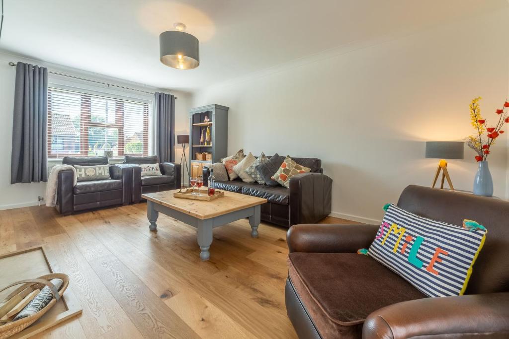 a living room with couches and a coffee table at One Lazy Duck in Heacham