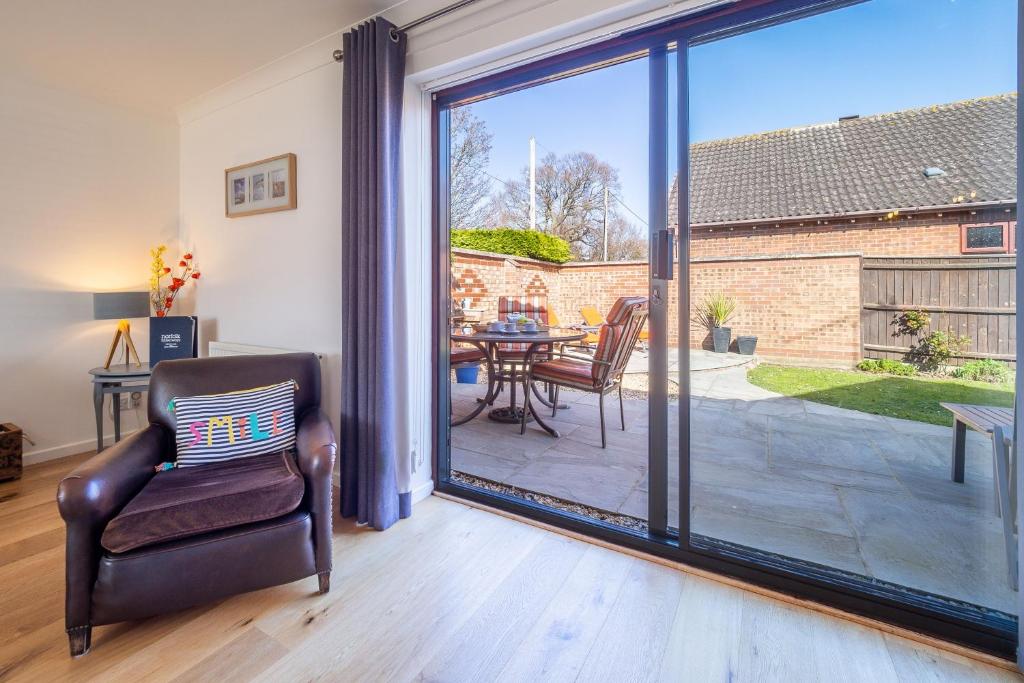 a living room with a sliding glass door with a table and chairs at One Lazy Duck in Heacham