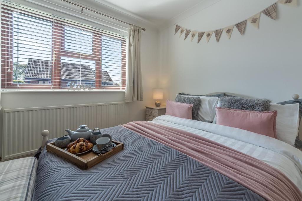a bedroom with a bed with a tray of food on it at One Lazy Duck in Heacham
