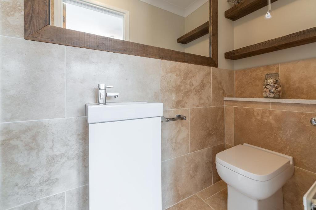 a bathroom with a toilet and a sink at One Lazy Duck in Heacham