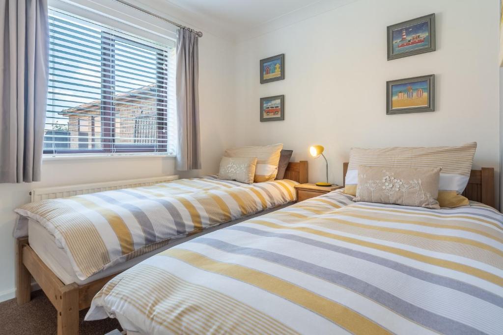 two beds sitting next to each other in a bedroom at One Lazy Duck in Heacham
