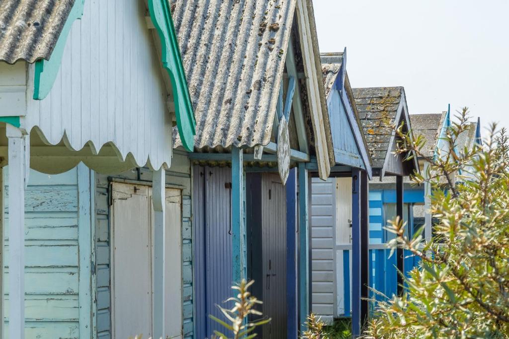 a row of beach houses with blue doors at One Lazy Duck in Heacham
