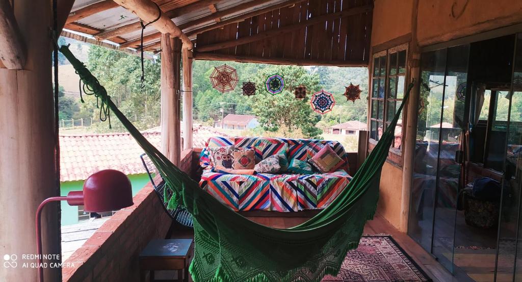 a man sleeping in a hammock in a porch at Sitio Alecrim Gastronomia e Hospedaria in Alagoa