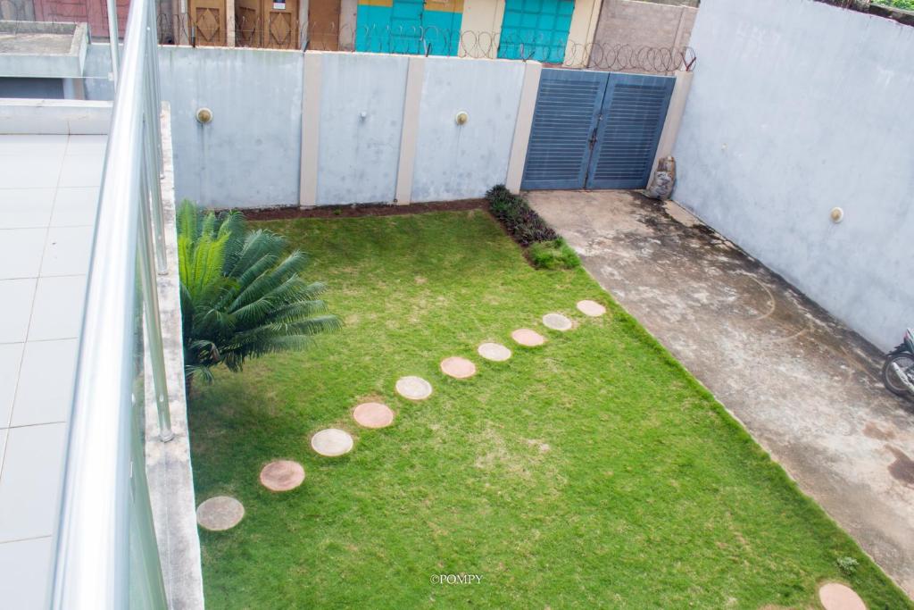 a small backyard with a yard with grass and rocks at EAGLE in Ouéto