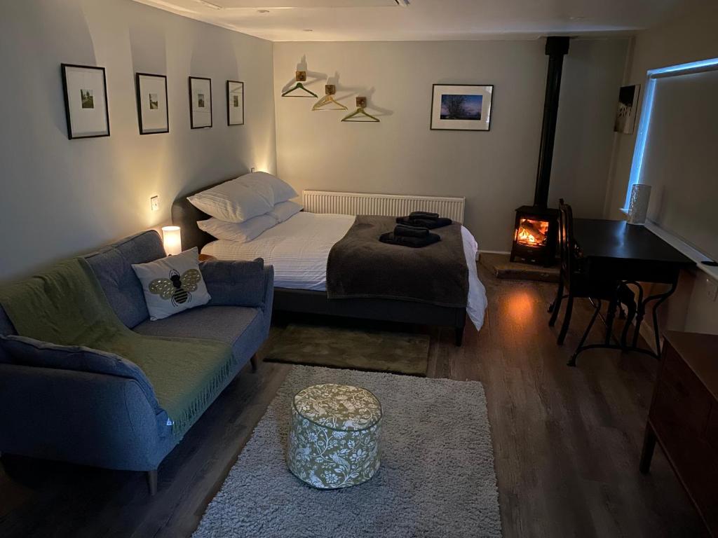 a bedroom with a bed and a couch and a piano at SPALDING - Self Contained Studio Double - An extra single bed can be provided in Lincolnshire