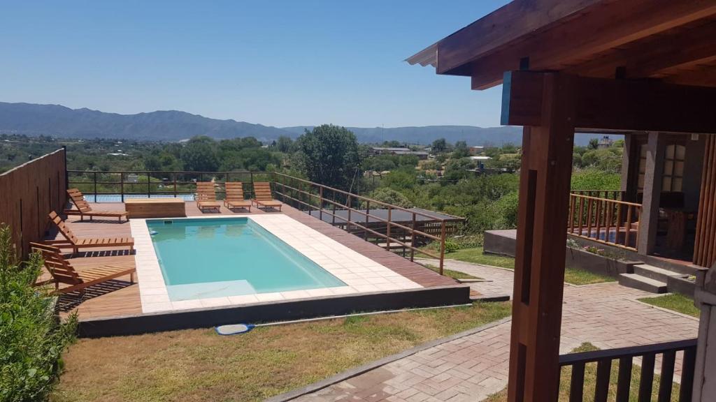 a swimming pool on a deck next to a house at Alojamiento Tanti in Villa Santa Cruz del Lago