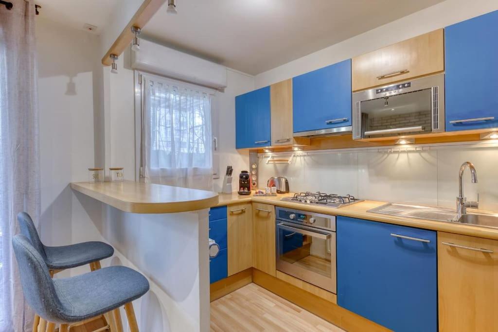 a kitchen with blue cabinets and a blue chair at La pépite bleue de Nanterre in Nanterre