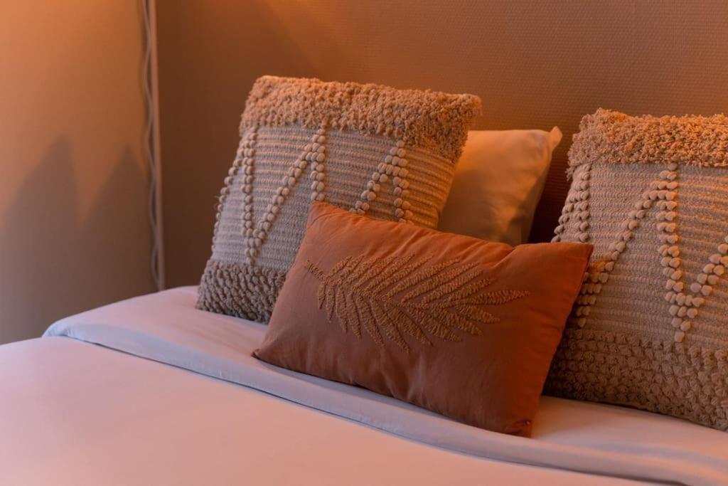 a bed with several pillows on top of it at La pépite bleue de Nanterre in Nanterre