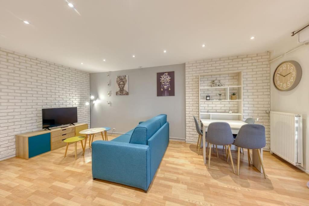 a living room with a blue couch and a table at La pépite bleue de Nanterre in Nanterre