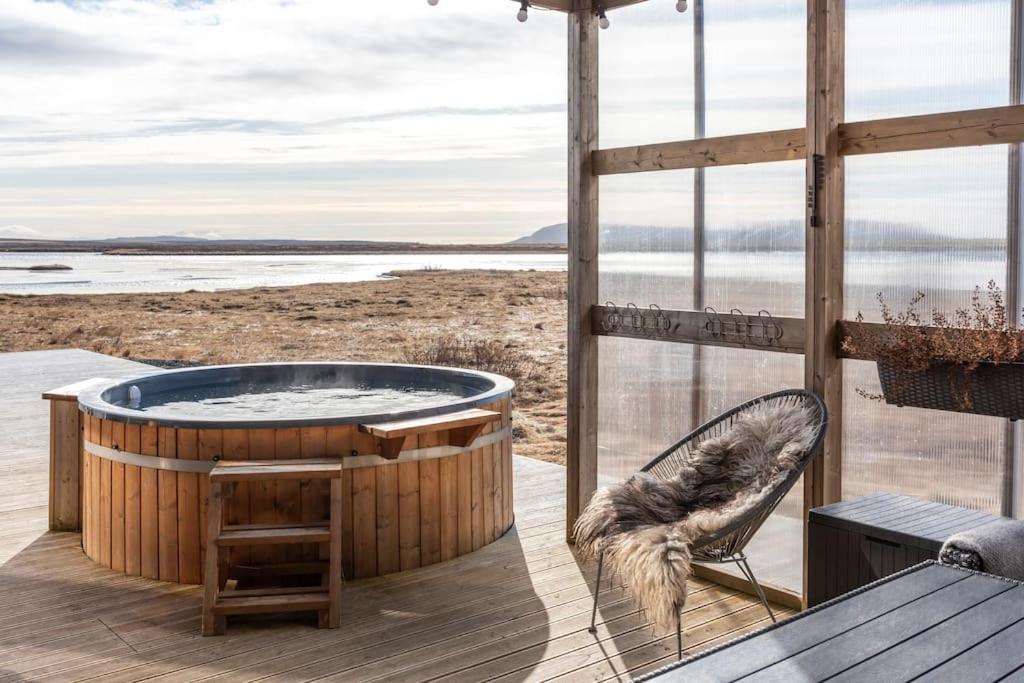 bañera de hidromasaje en una terraza con vistas al océano en Villa with good View Laugarvatn, en Patreksfjördur