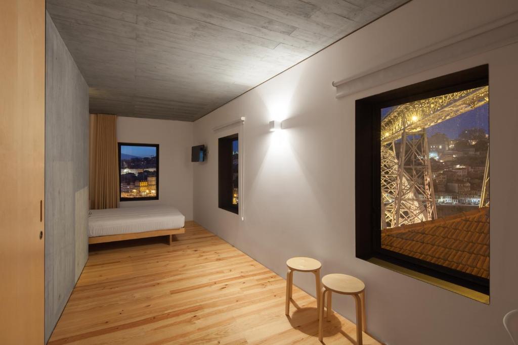 een kamer met 2 krukken, een bed en een raam bij Oh! Porto - Whole Property in Vila Nova de Gaia
