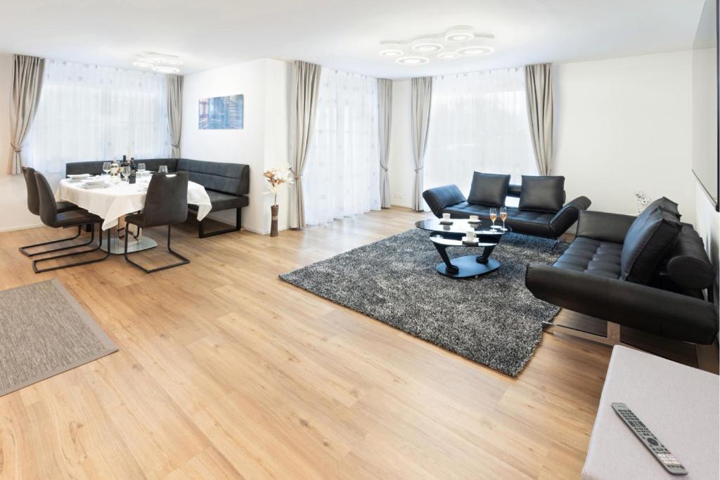 sala de estar con muebles negros y mesa en Exklusive 2,5 Zimmer Wohnung en Eschenz