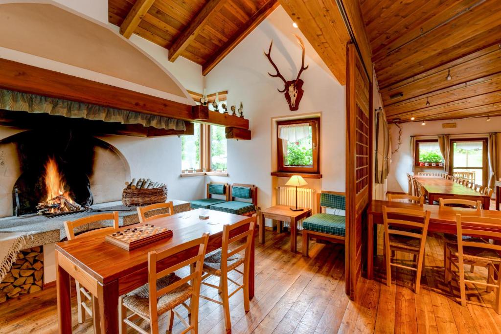 a living room with a fireplace and a table and chairs at Chalet Casa Al Campo in Giustino