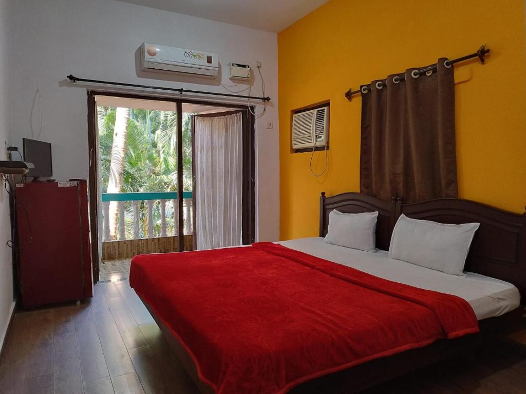 een slaapkamer met een bed met een rode deken bij Casa De Rocks in Calangute
