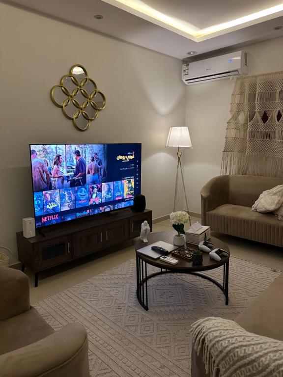 ein Wohnzimmer mit einem großen Flachbild-TV in der Unterkunft غرفة وصالة بحي الربيع in Riad
