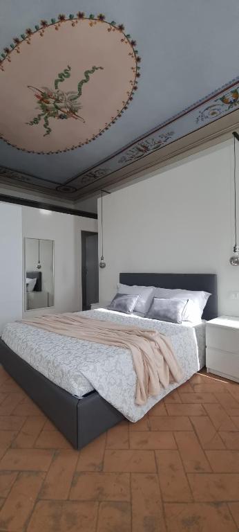 a bedroom with a large bed with a ceiling at Guest House Palazzo Buoninsegni in Colle Val D'Elsa