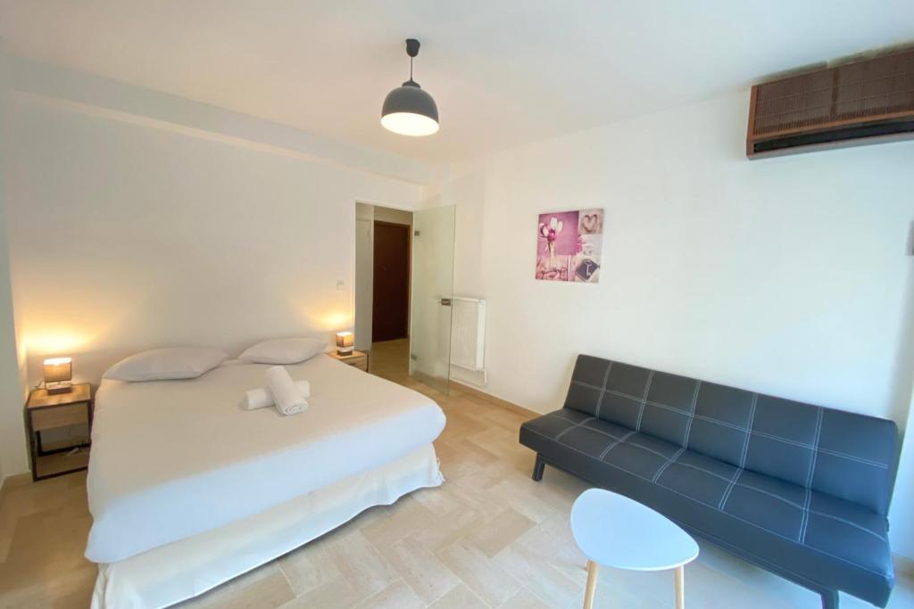 um quarto com uma cama e um sofá em 06BG - Studio 600m from the beach - private parking em Cagnes-sur-Mer