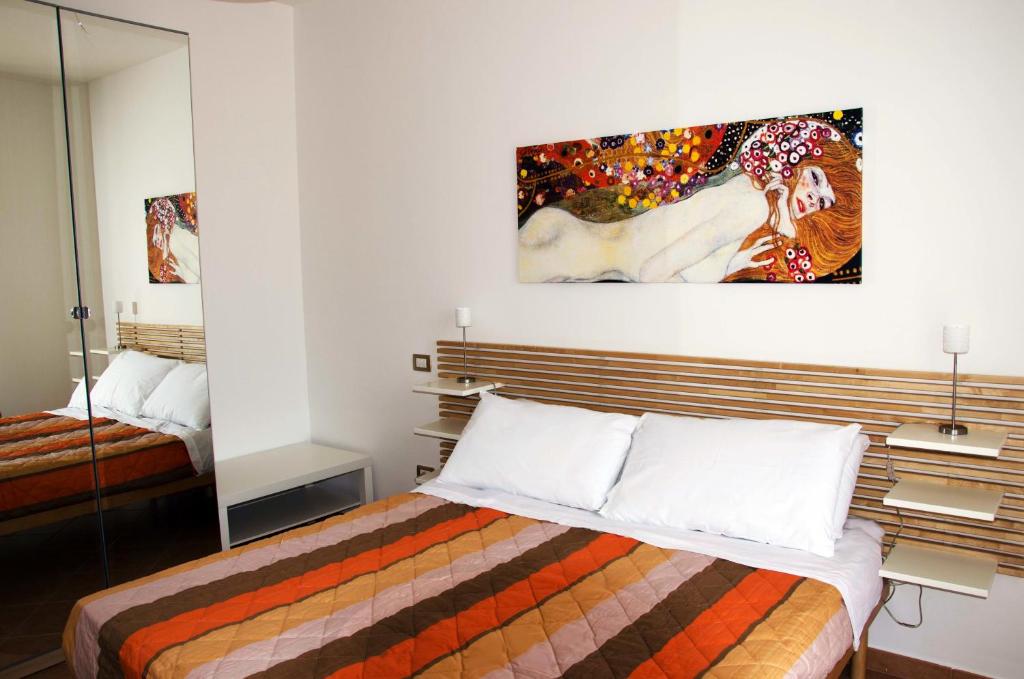 una camera da letto con un letto e un dipinto sul muro di Aliseo B&B a Lecce