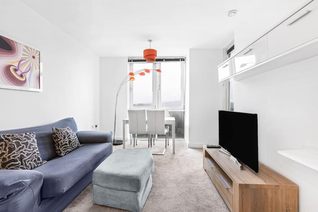 uma sala de estar com um sofá azul e uma televisão em High Spec 2 Bed, 2 Bath, Wi-Fi, Balcony em Hemel Hempstead