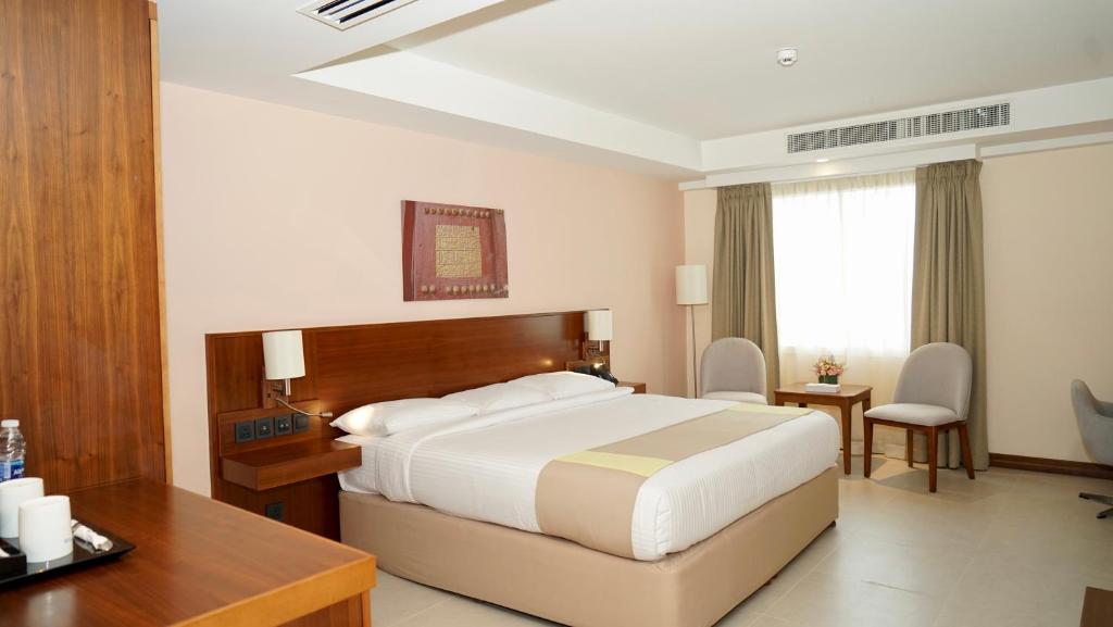 um quarto de hotel com uma cama e uma secretária em KYRIAD HOTEL SALALAH em Salalah