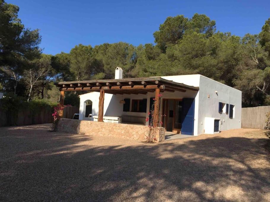 a small white house with a wooden roof at A beautiful villa close to the beach in Playa Migjorn