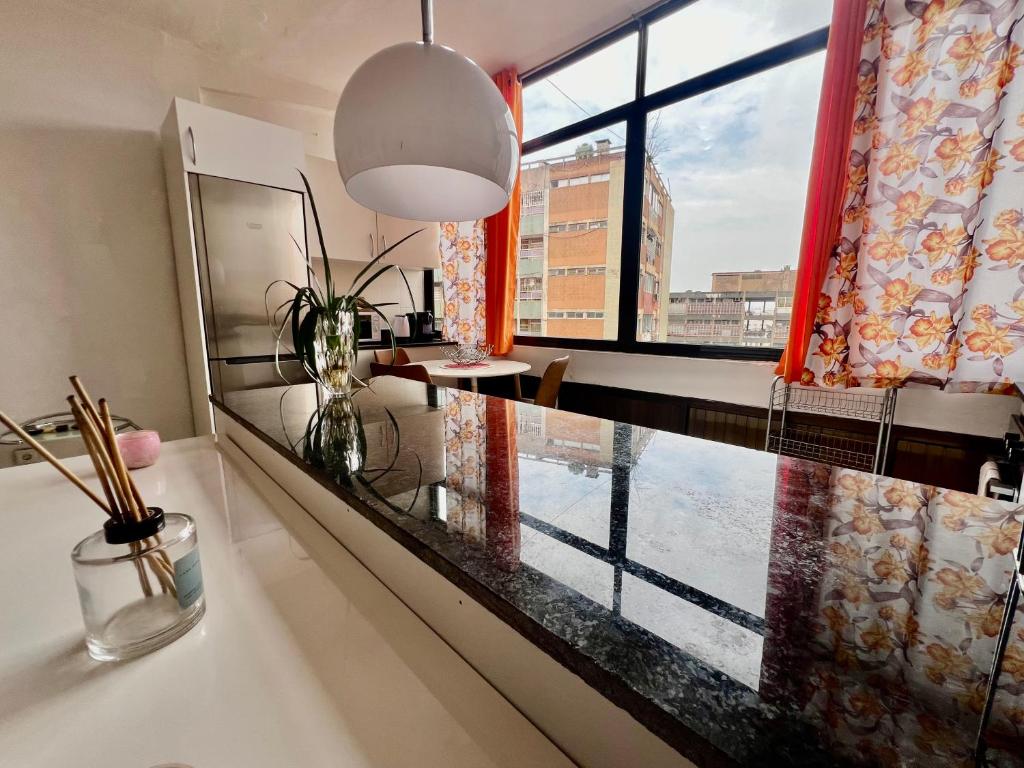 ein Wohnzimmer mit einem großen Fenster und einem Tisch in der Unterkunft A 5 minutos do aeroporto! La Vie com estacionamento privado in Luanda
