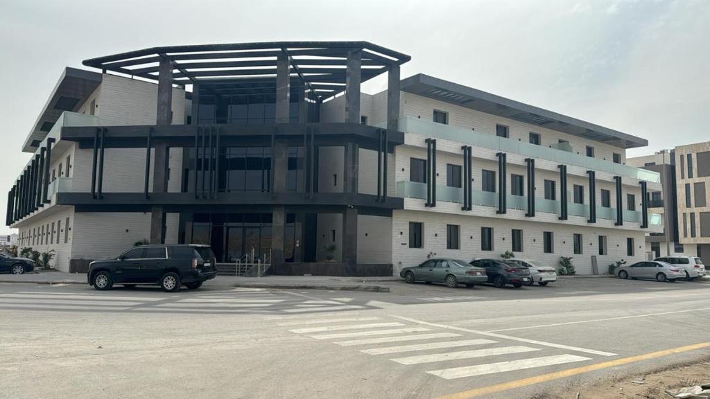 duży budynek z samochodami zaparkowanymi na parkingu w obiekcie Al Azmy Al Ared Hotel w Rijadzie