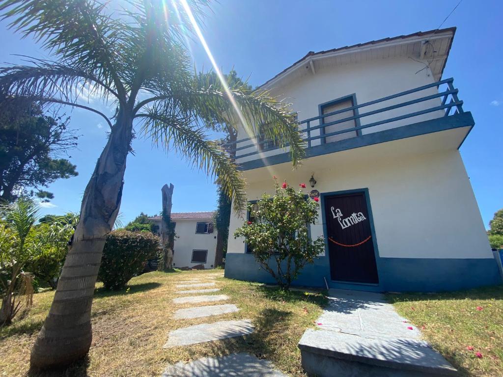 a building with a palm tree in front of it at Lomita Gesell in Villa Gesell