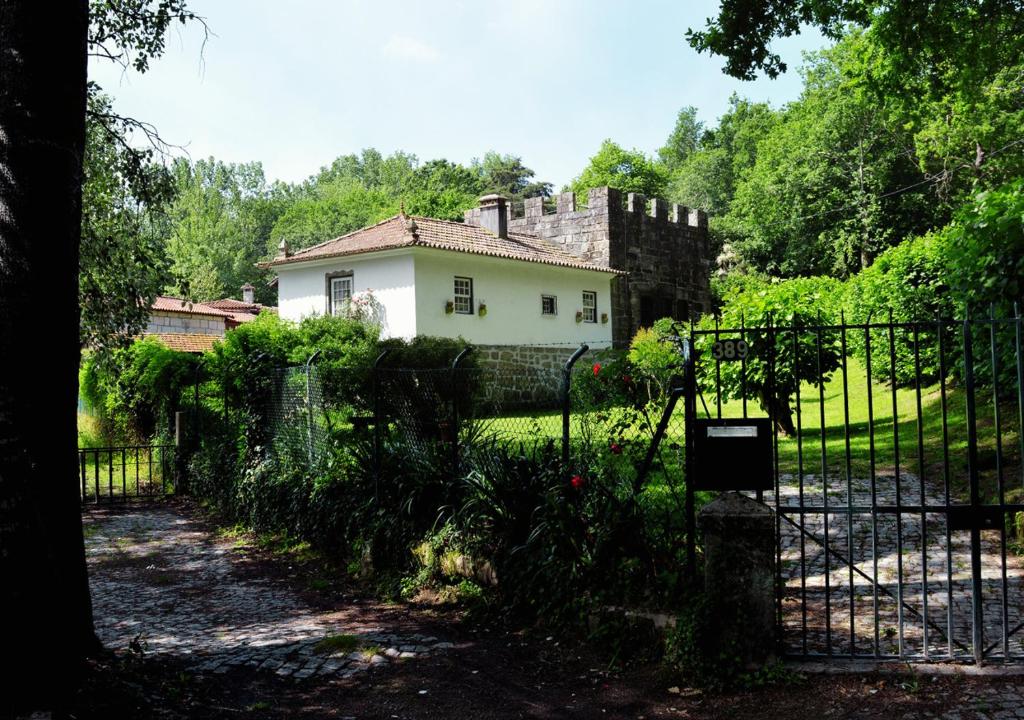 a gate in front of a house with a castle at Casa de Travassos in Luzim