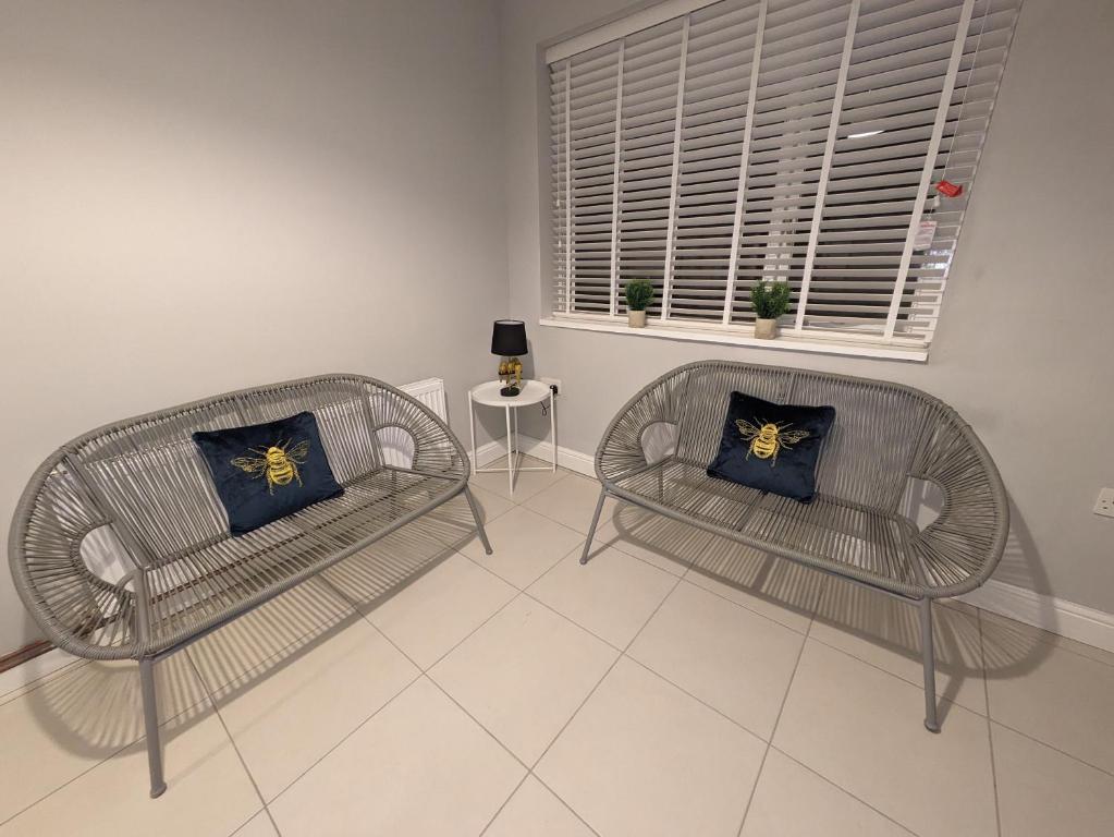 a living room with two chairs and a window at Airfield Manor in Castle Donington