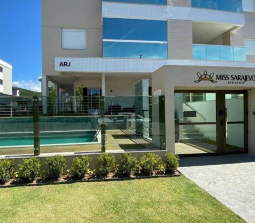 ein großes Gebäude mit einem Swimmingpool davor in der Unterkunft Miss Sarajevo Praia Palmas Governador Celso Ramos in Governador Celso Ramos