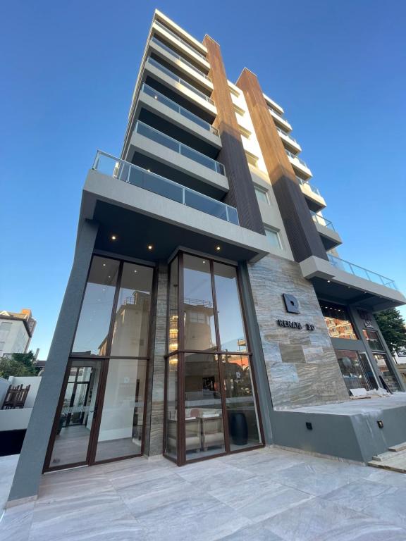a tall building with glass doors in front of it at Casa Pancha in Pinamar