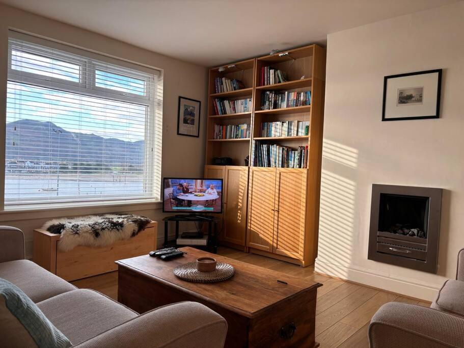 a living room with a couch and a table and a tv at Beautiful 2 bedroom apartment with estuary views in Deganwy
