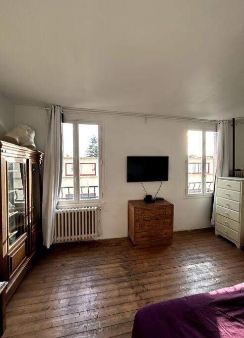 un salon avec une télévision à écran plat au mur dans l'établissement Maison 50m2 proche Paris pour 2, à Pantin