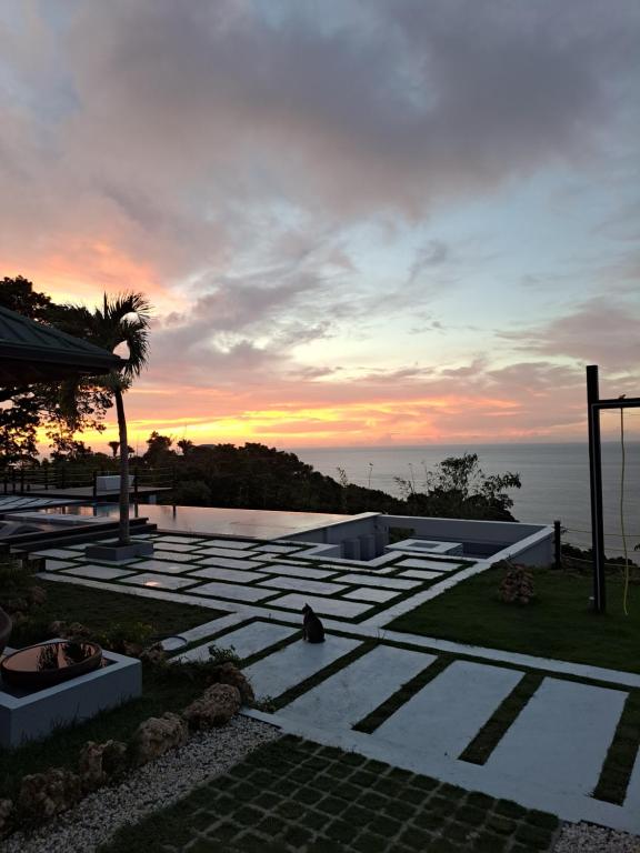 a sunset over a patio with a view of the ocean at Silk Cotton Cottages in Parrot Hall