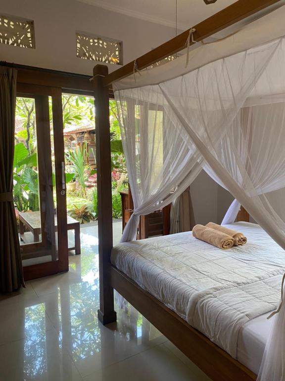 una camera con letto a baldacchino di GUS ARDITYA HOMESTAY ad Ubud