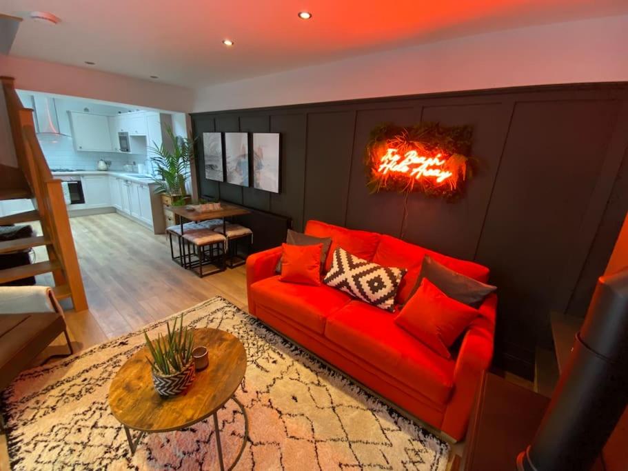 a living room with a red couch and a table at Hot Tub, King Bed, Central, Modern Beach House in Cleethorpes