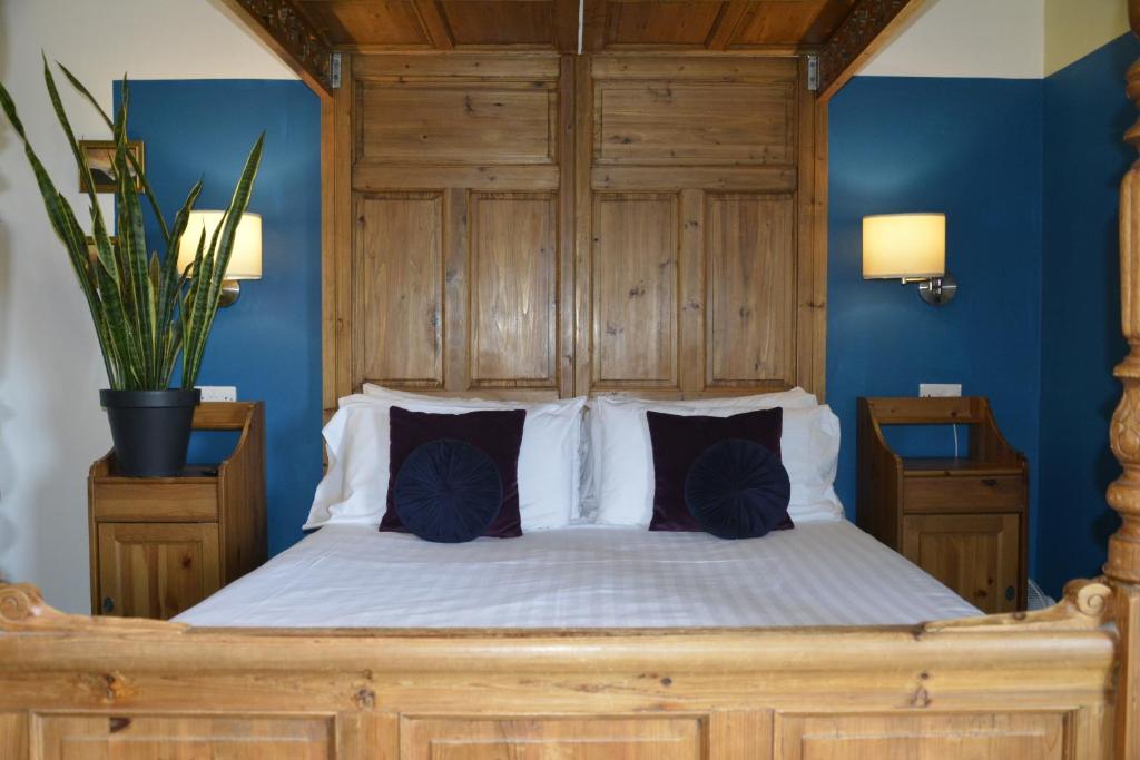 um quarto com uma cama grande e uma cabeceira em madeira em Park Broom Lodges - Caldew House - Eden House - Petteril House em Carlisle