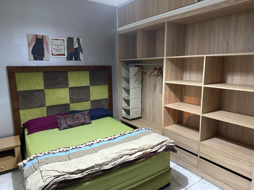 - une chambre avec un lit et quelques étagères dans l'établissement Apparemment TAMARIS, à Dar Bouazza