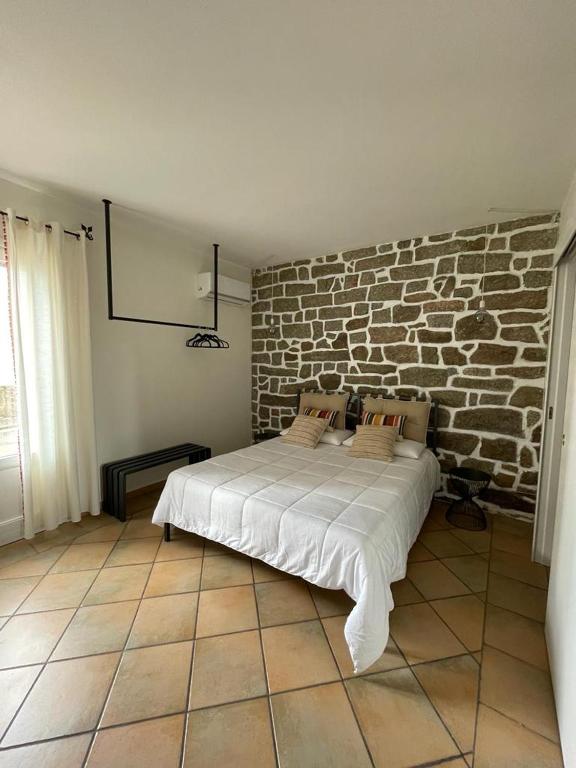 Bett in einem Zimmer mit Ziegelwand in der Unterkunft Excellent Rooms Paola's in Olbia