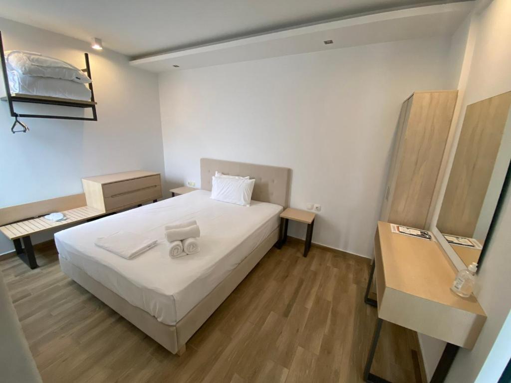 una camera con letto bianco e pavimento in legno di Coral Boutique Apartments a Ofrínion