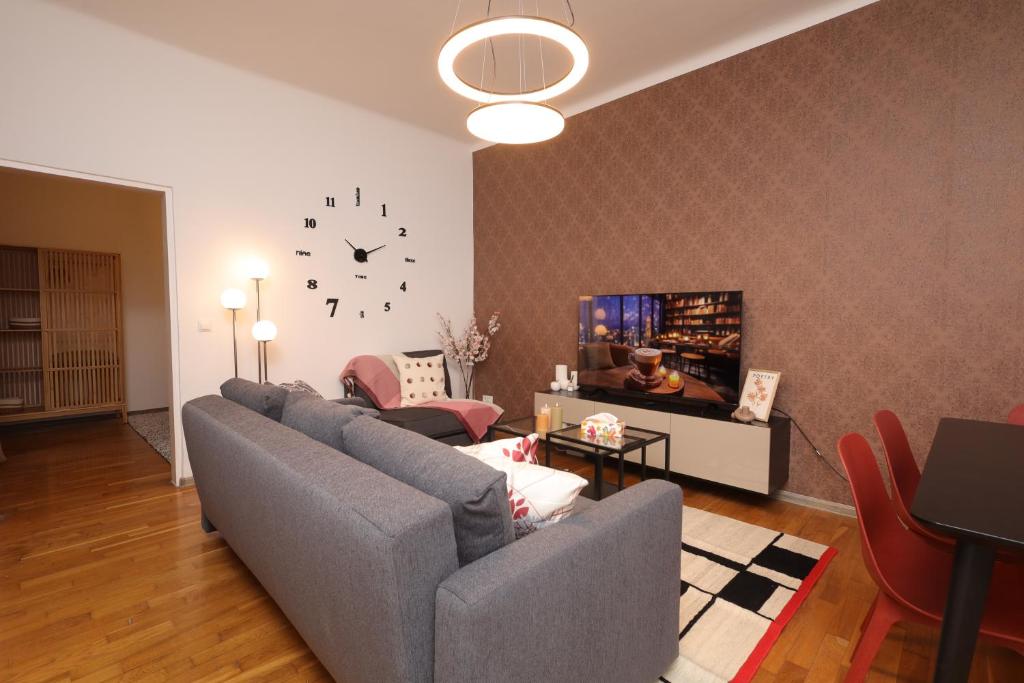 a living room with a couch and a clock on the wall at Ruby holiday home with patio in Vienna