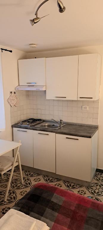 kuchnia z białymi szafkami i piekarnikiem w obiekcie Studio Bandiera apartment w mieście Palermo