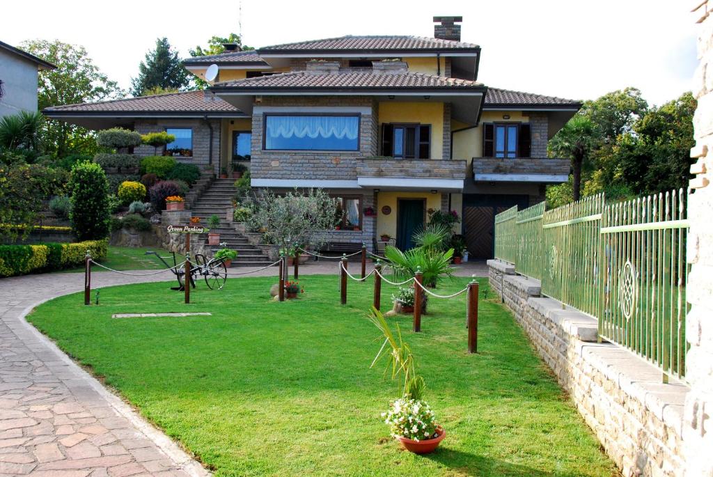 une maison avec un jardin en face dans l'établissement B&B Le Palme, à Bassano Romano